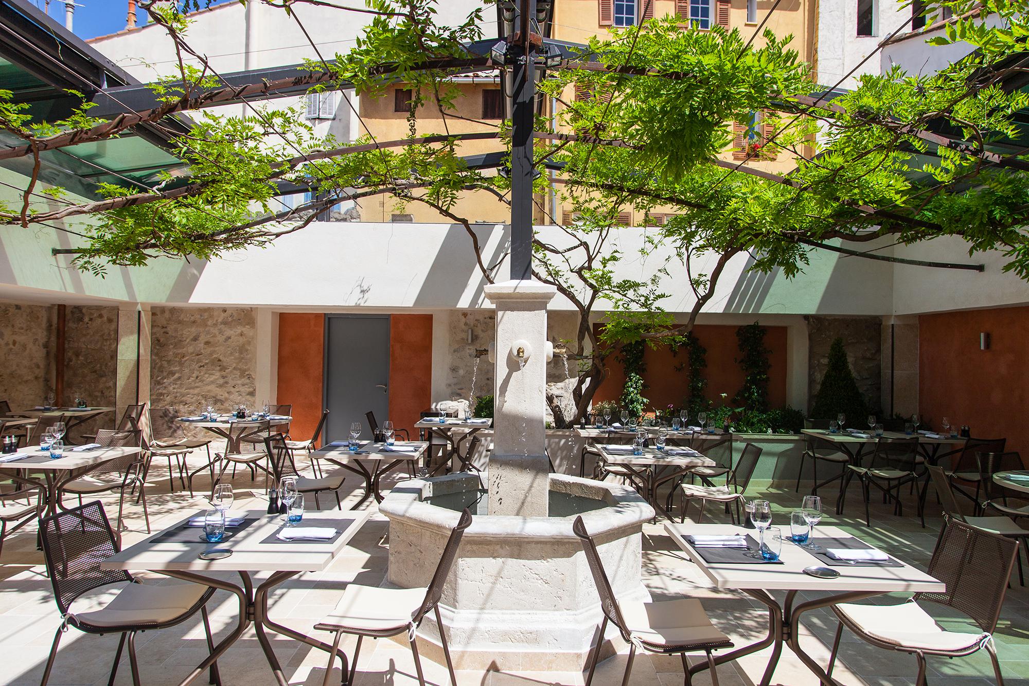 Patio du Nacional Trattoria sous la glycine, fontaine centrale, tables dressées